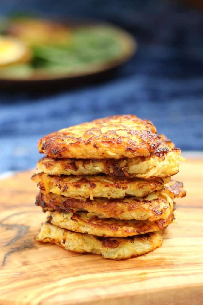 closeup photo of cooked squash apple fritters stacked on a board