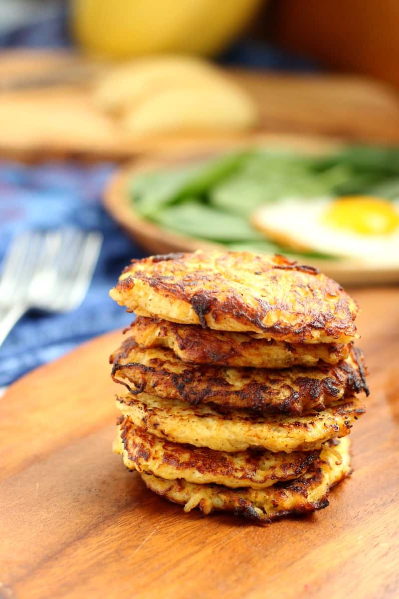 six browned spaghetti squash apple fritters stacked on a board