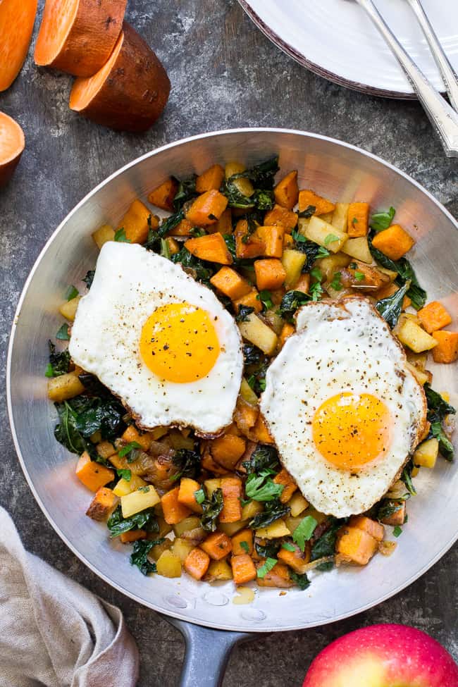 skillet of sweet potato hash with two fried eggs on top