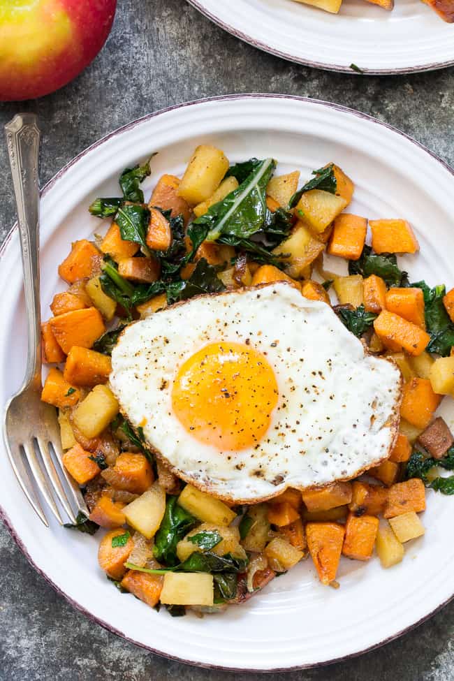 hash with a fried egg on top served on a white plate