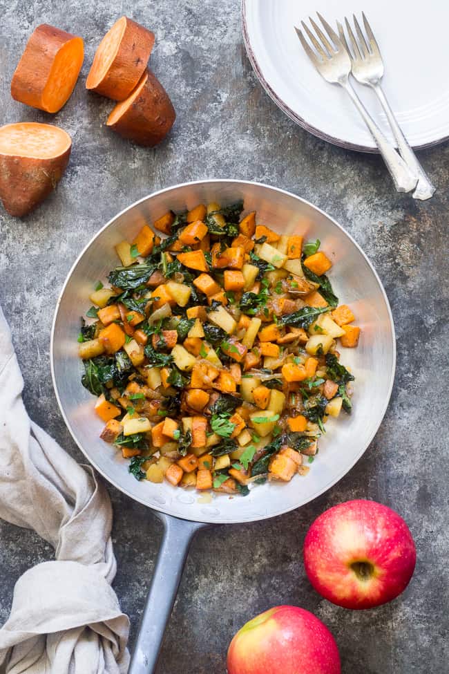 stainless steel skillet filled with sweet potato, apple, and kale hash