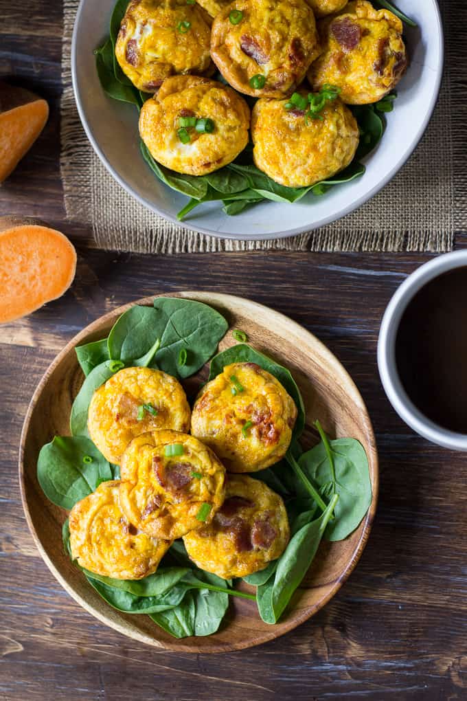 two bowls of sweet potato bacon egg muffins on a wooden tablescape