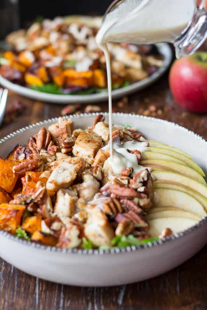 maple cider salad dressing being poured over a salad