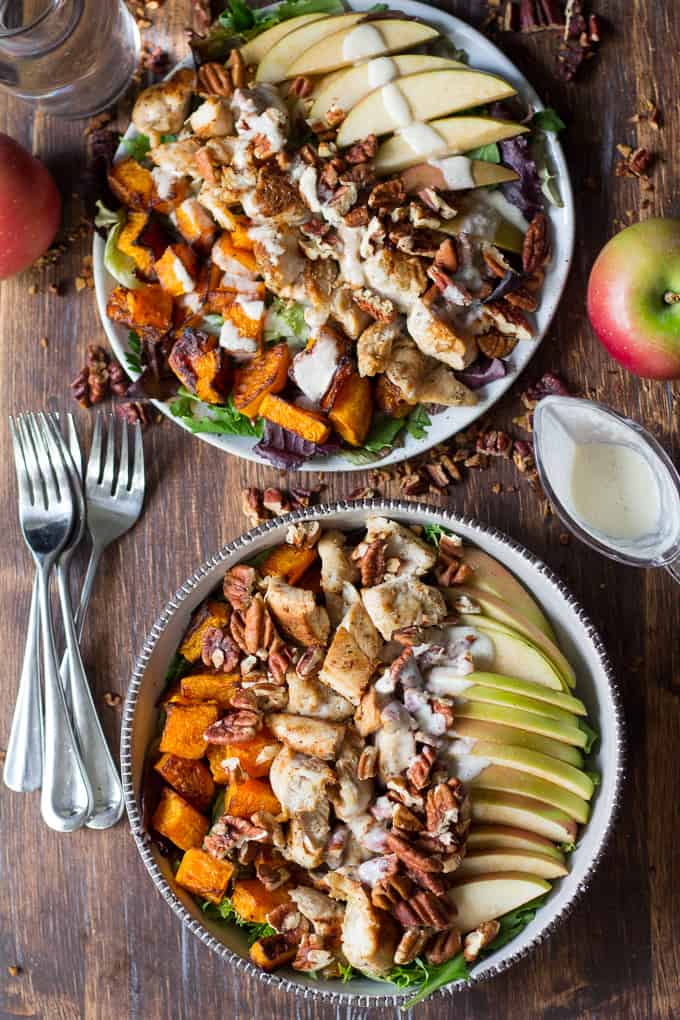 two servings of apple butternut chicken salad on a wooden background