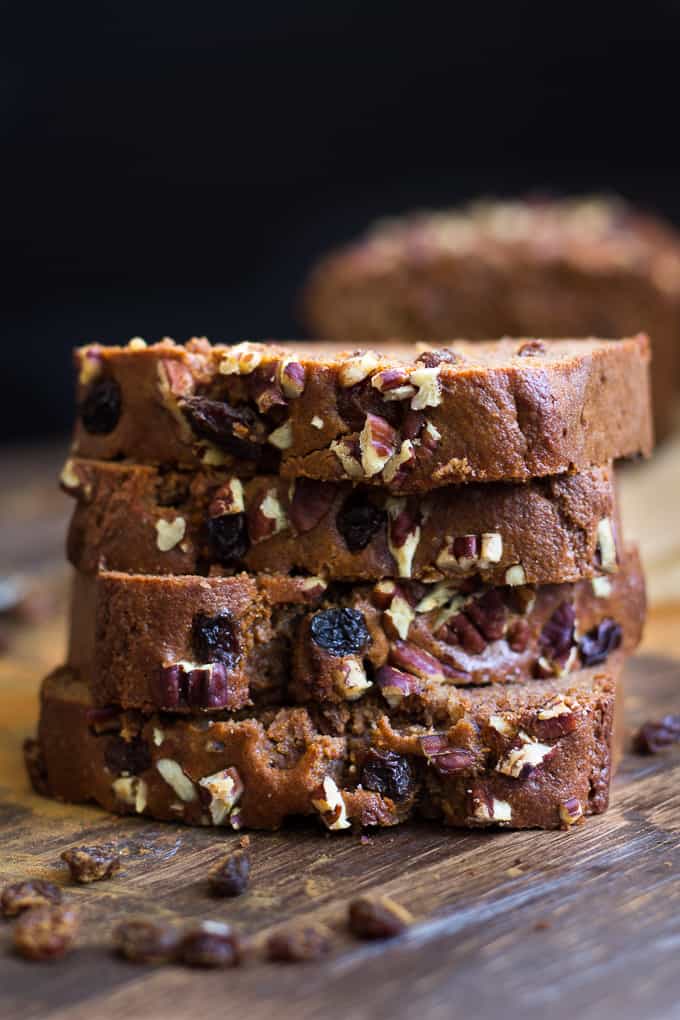 a stack of four slices of brown bread with raisin and pecan topping