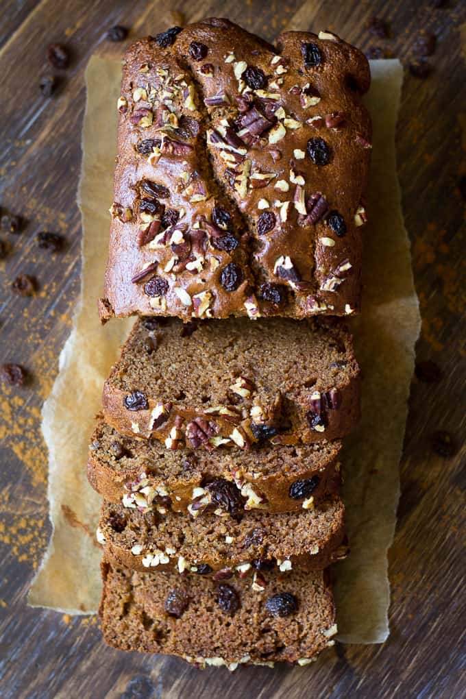 sliced loaf of cinnamon raisin applesauce bread topped with raisins and pecans