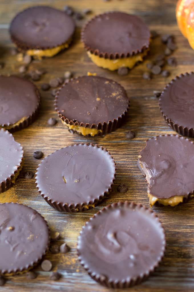 pumpkin pie caramel chocolate cups arranged on a wooden board