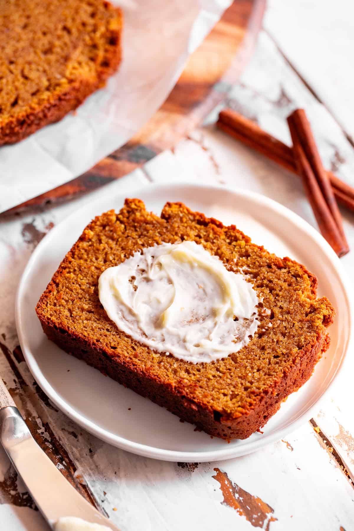 Slice of paleo pumpkin bread spread with dairy free butter