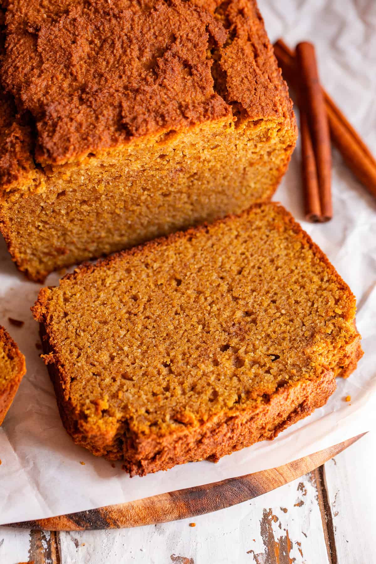Thick slice of moist paleo pumpkin bread showing the tender pumpkin crumb