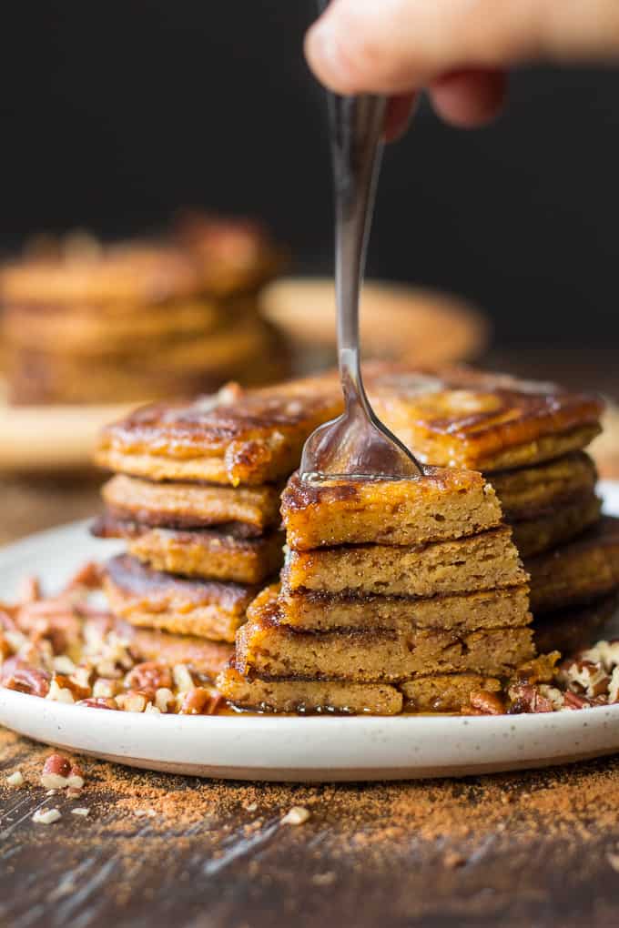 a fork taking a bite out of a stack of paleo pumpkin pancakes
