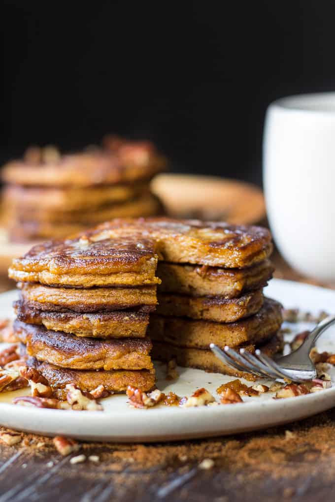 a stack of paleo pancakes with a wedge taken out, a fork lies beside the stack