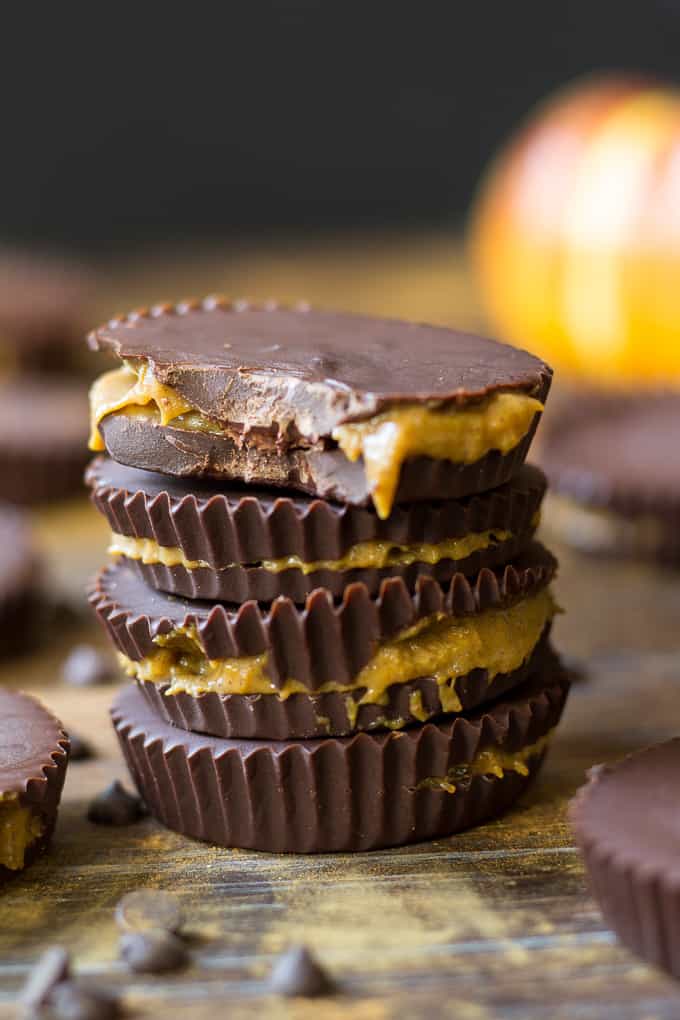 a stack of three gooey pumpkin caramel chocolate cups on a board