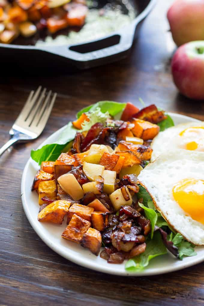 butternut squash hash and two eggs over a bed of greens