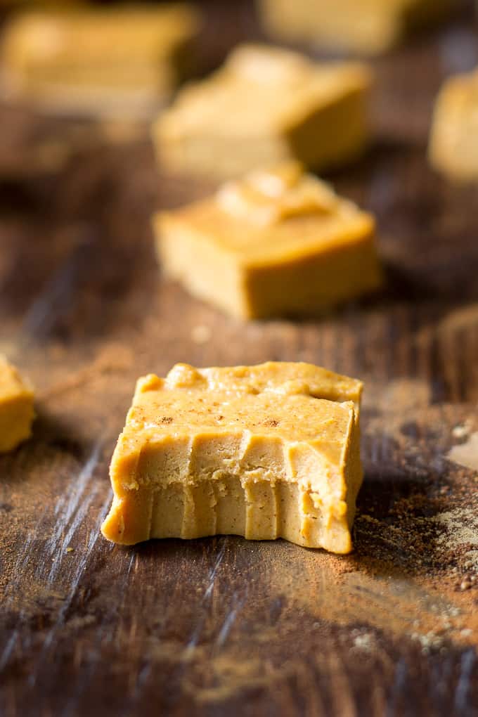 a piece of light orange-brown paleo pumpkin fudge with a bite taken out