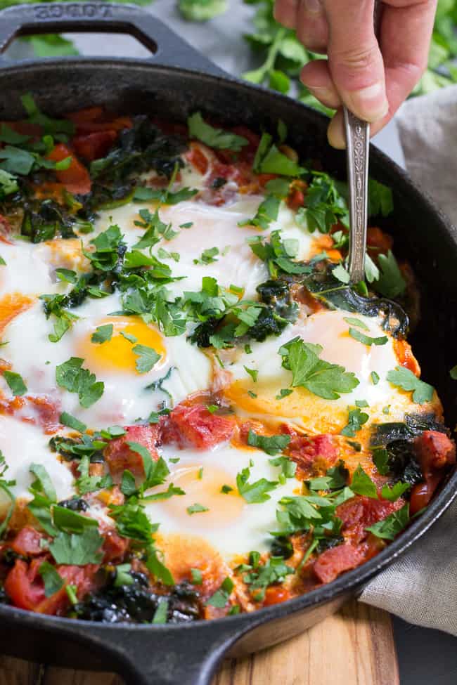 Eggs simmer in a spicy tomato sauce with kale and sausage in this savory and filling Shakshuka. This Paleo and Whole30 Shakshuka makes a comforting and healthy meal for brunch, dinner, or whenever!