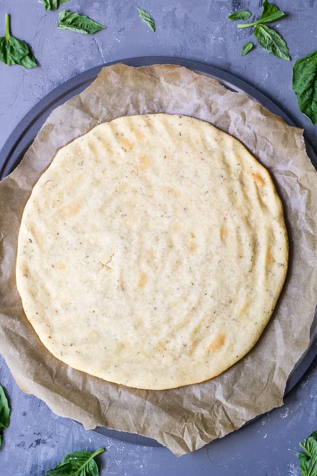 This quick and easy paleo pizza crust will be your new go-to whenever a pizza craving strikes! The ingredients mix together in one bowl and it's ready in under 30 minutes. Top it however you like for any meal! Kid friendly, gluten free, grain free, dairy free.