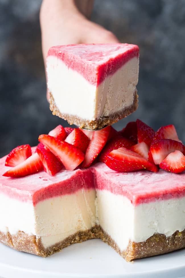 This no-bake Paleo and vegan cheesecake has a chewy, naturally sweet crust, topped with a thick creamy lemon layer and a sweet creamy strawberry layer. The cheesecake layers have a cashew base, come together quickly in a blender or food processor, and are then chilled to set. Gluten free, dairy free, refined sugar free.