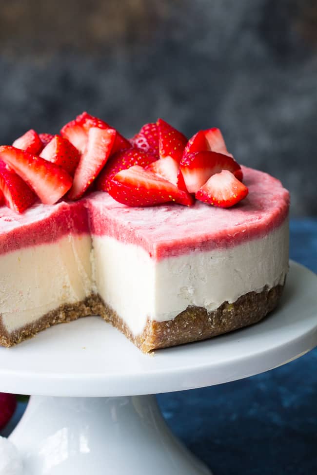 This no-bake Paleo and vegan cheesecake has a chewy, naturally sweet crust, topped with a thick creamy lemon layer and a sweet creamy strawberry layer. The cheesecake layers have a cashew base, come together quickly in a blender or food processor, and are then chilled to set. Gluten free, dairy free, refined sugar free.