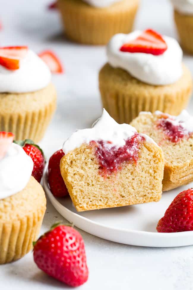 These Strawberry Shortcake Cupcakes start with a perfect paleo vanilla cupcake, filled with honey sweetened strawberry preserves and topped with thick and creamy coconut whipped cream. They're gluten free, dairy free, kid approved, fun to make, and perfect for any special occasion or holiday!