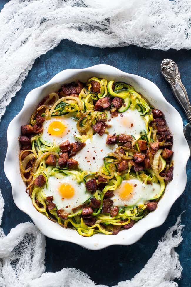 This spicy zucchini noodle egg bake is loaded with sautéed onions, spicy sausage, crispy bacon and of course eggs!  Perfect for breakfast, lunch or dinner, it's Paleo, Whole30 and low carb.