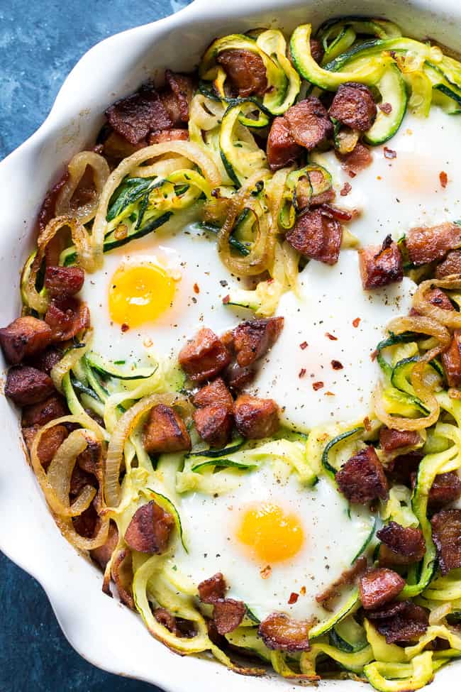 This spicy zucchini noodle egg bake is loaded with sautéed onions, spicy sausage, crispy bacon and of course eggs!  Perfect for breakfast, lunch or dinner, it's Paleo, Whole30 and low carb.