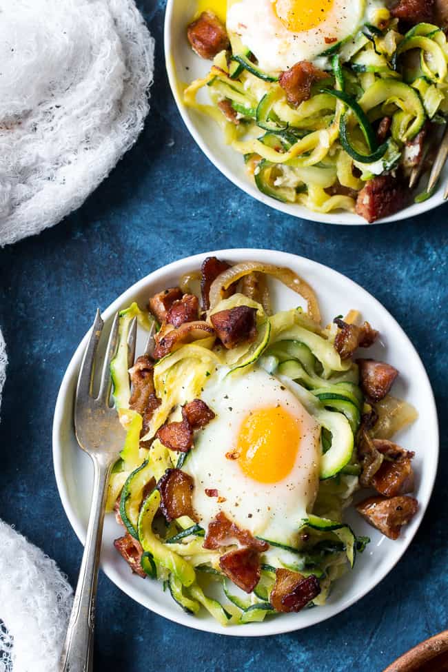 This spicy zucchini noodle egg bake is loaded with sautéed onions, spicy sausage, crispy bacon and of course eggs!  Perfect for breakfast, lunch or dinner, it's Paleo, Whole30 and low carb.