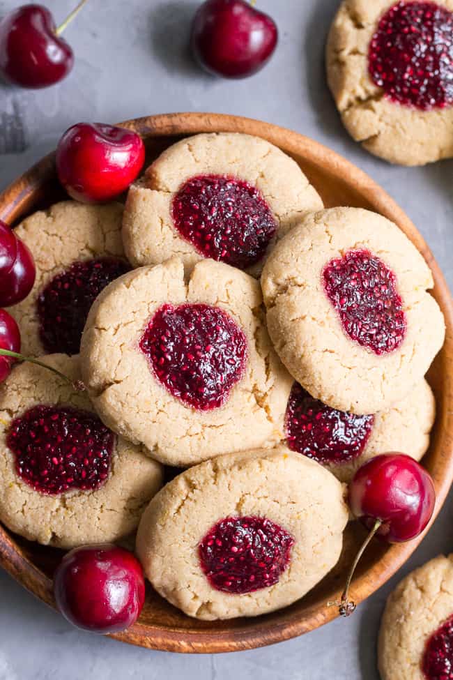 These chewy lemon almond thumbprint cookies are filled with cherry chia jam and are healthy, paleo, vegan, kid approved, and easy to make.  They taste buttery and decadent but are gluten free and dairy free!