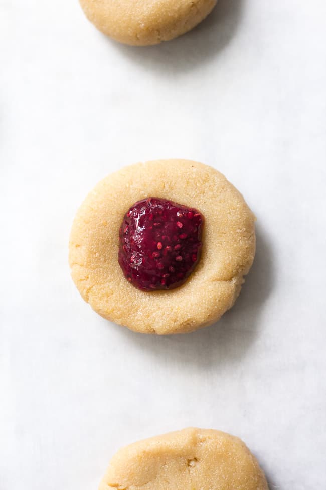 These chewy lemon almond thumbprint cookies are filled with cherry chia jam and are healthy, paleo, vegan, kid approved, and easy to make.  They taste buttery and decadent but are gluten free and dairy free!