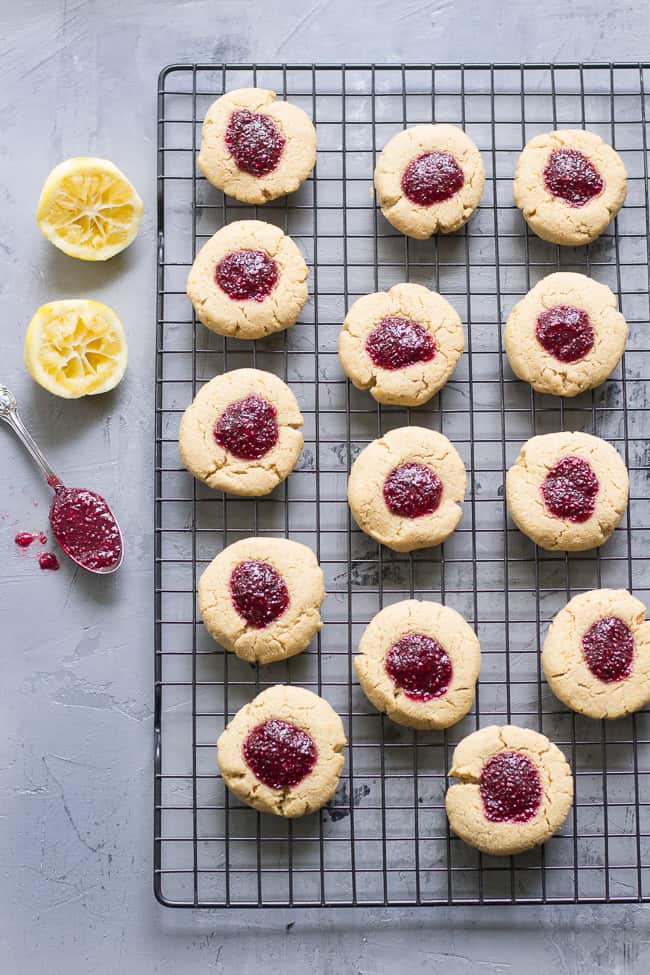 These chewy lemon almond thumbprint cookies are filled with cherry chia jam and are healthy, paleo, vegan, kid approved, and easy to make.  They taste buttery and decadent but are gluten free and dairy free!