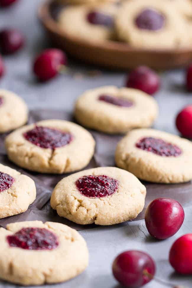 These chewy lemon almond thumbprint cookies are filled with cherry chia jam and are healthy, paleo, vegan, kid approved, and easy to make.  They taste buttery and decadent but are gluten free and dairy free!