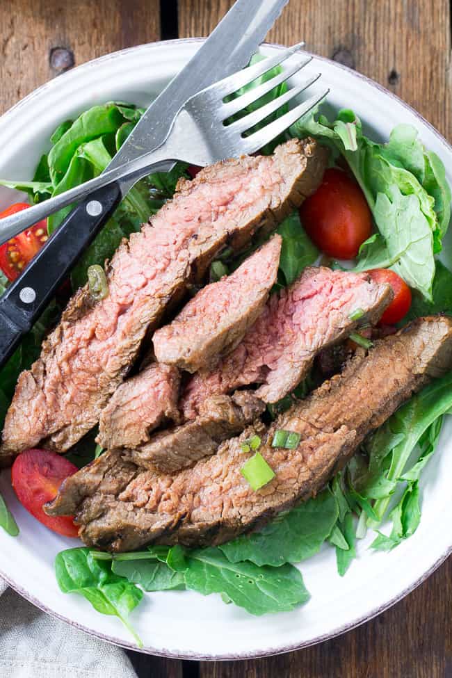 This Paleo and Whole30 grilled marinated flank steak will become your go-to recipe to top salads or serve with your favorite grilled veggies and potatoes. The marinade comes together in a blender and can be boiled into a sauce to serve with the steak. Gluten free, refined sugar free, soy free, dairy free.