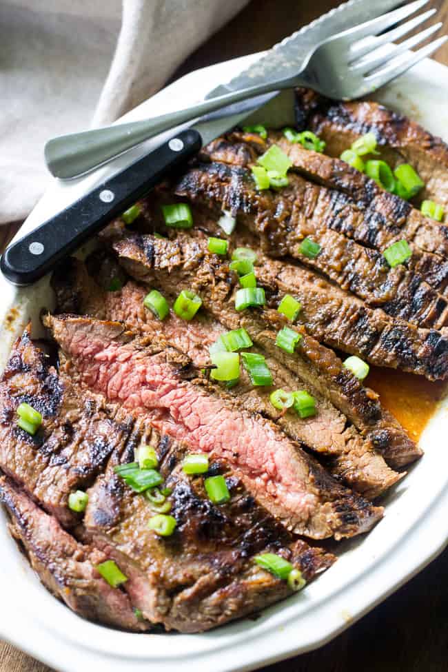 This Paleo and Whole30 grilled marinated flank steak will become your go-to recipe to top salads or serve with your favorite grilled veggies and potatoes. The marinade comes together in a blender and can be boiled into a sauce to serve with the steak. Gluten free, refined sugar free, soy free, dairy free.
