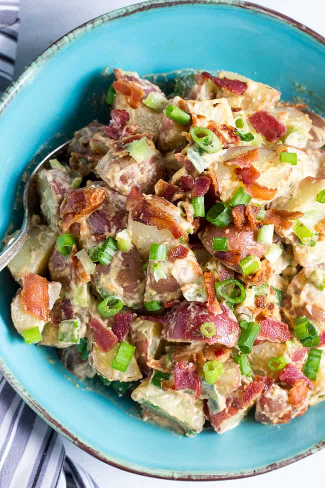 This creamy ranch potato salad is loaded with savory crispy bacon, green onions and couldn't be easier to make!  A homemade Paleo and Whole30 ranch dressing gives this potato salad a zesty, addicting "cheesy" flavor even though it's dairy-free!   