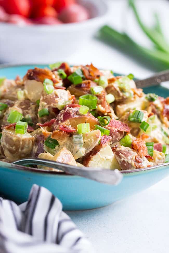 This creamy ranch potato salad is loaded with savory crispy bacon, green onions and couldn't be easier to make!  A homemade Paleo and Whole30 ranch dressing gives this potato salad a zesty, addicting "cheesy" flavor even though it's dairy-free!   