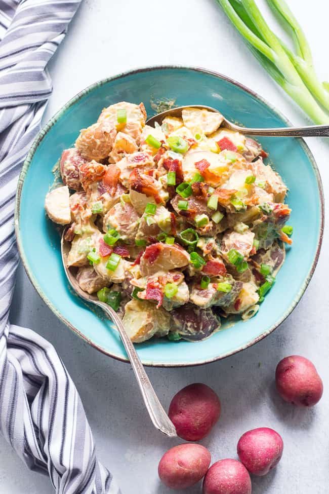 This creamy ranch potato salad is loaded with savory crispy bacon, green onions and couldn't be easier to make!  A homemade Paleo and Whole30 ranch dressing gives this potato salad a zesty, addicting "cheesy" flavor even though it's dairy-free!   