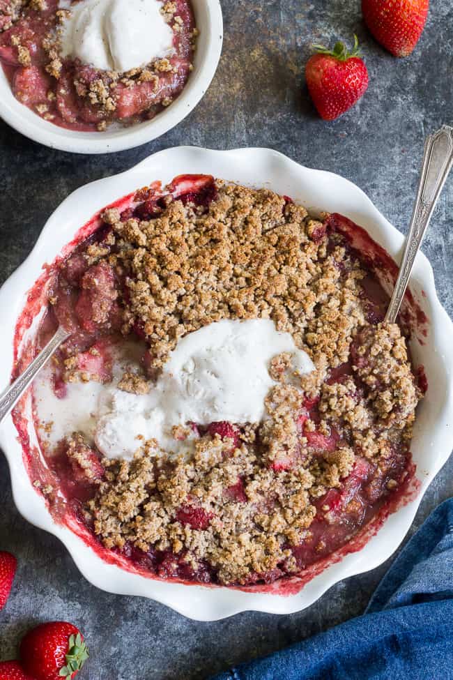 This paleo & vegan strawberry crumble couldn't be easier or more delicious! Made without refined sugar, grains, or dairy, it's a healthy summer dessert that will make everyone happy. A big scoop of coconut vanilla ice cream makes it the perfect treat! Gluten-free, dairy-free, paleo and vegan.