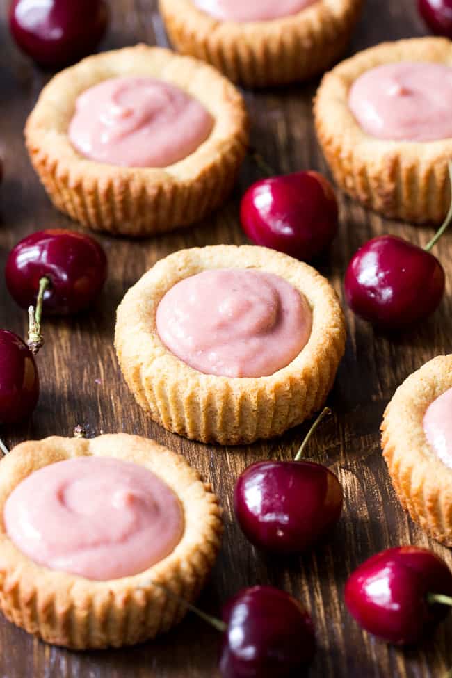 Thick, creamy and sweet cherry curd made from fresh cherries is spooned into grain free and paleo cookie tarts for a delicious, fun and secretly healthy dessert!   Dairy free, refined sugar free, gluten-free and paleo.