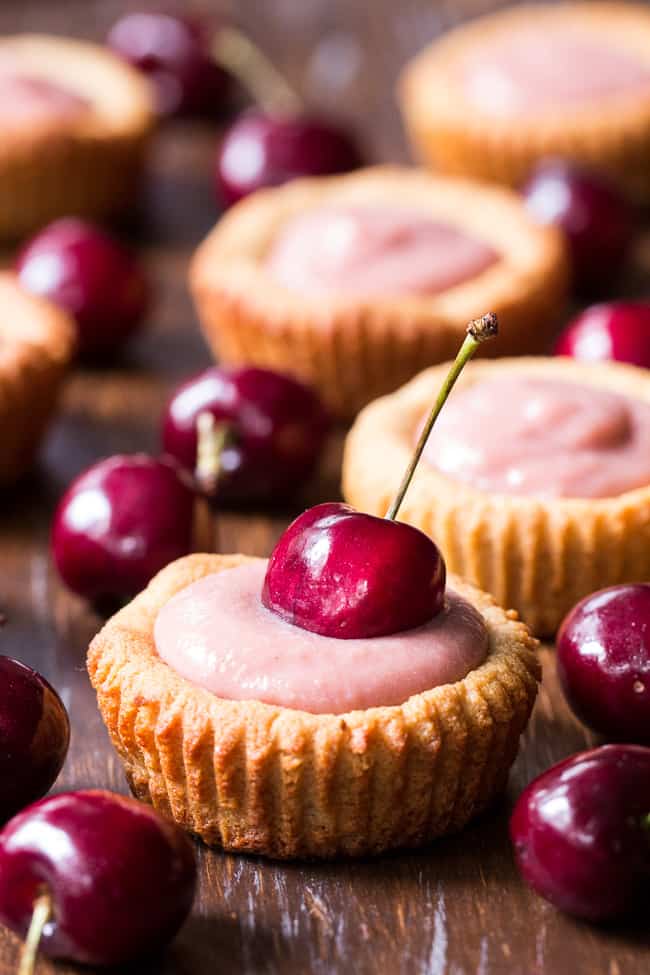 Thick, creamy and sweet cherry curd made from fresh cherries is spooned into grain free and paleo cookie tarts for a delicious, fun and secretly healthy dessert!   Dairy free, refined sugar free, gluten-free and paleo.