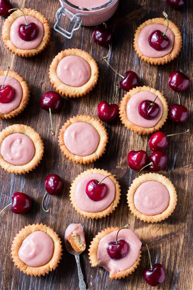 Thick, creamy and sweet cherry curd made from fresh cherries is spooned into grain free and paleo cookie tarts for a delicious, fun and secretly healthy dessert!   Dairy free, refined sugar free, gluten-free and paleo.