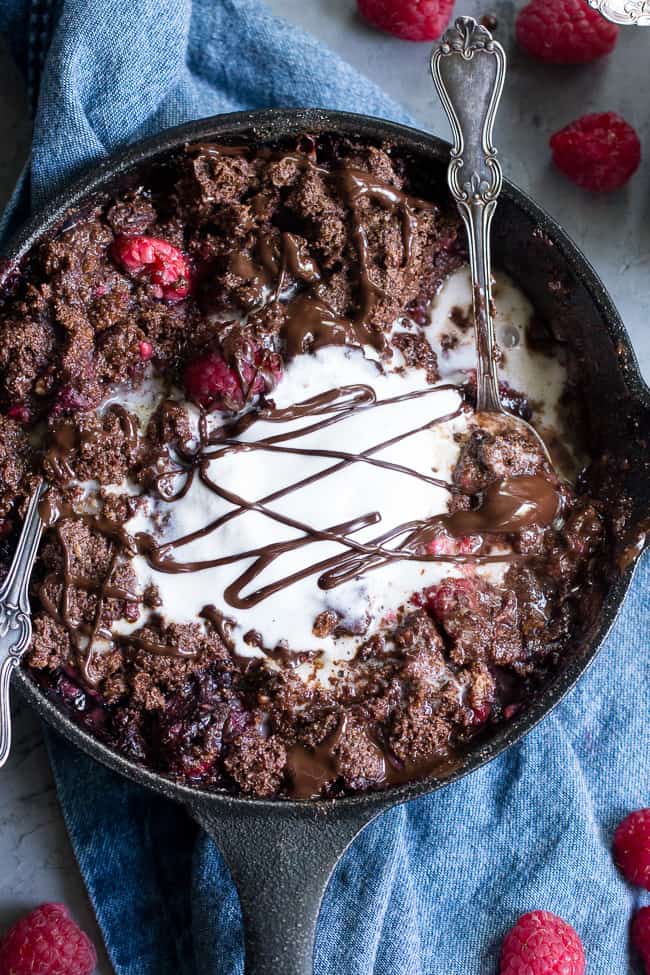 This raspberry chocolate crumble is super easy to make, paleo, vegan, and can be served right out of the skillet!   It's extra tasty topped with melted chocolate and coconut vanilla ice cream.   Gluten free, refined sugar free, dairy free.