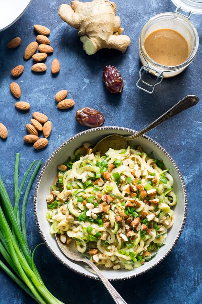 These almond butter sesame zucchini noodles are a delicious healthy makeover of classic sesame peanut noodles!  The creamy almond butter sauce is sweetened just the right amount with dates and loaded with chopped almonds and scallions.  Paleo, Whole30, and Vegan too! 