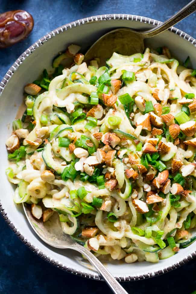 These almond butter sesame zucchini noodles are a delicious healthy makeover of classic sesame peanut noodles!  The creamy almond butter sauce is sweetened just the right amount with dates and loaded with chopped almonds and scallions.  Paleo, Whole30, and Vegan too! 