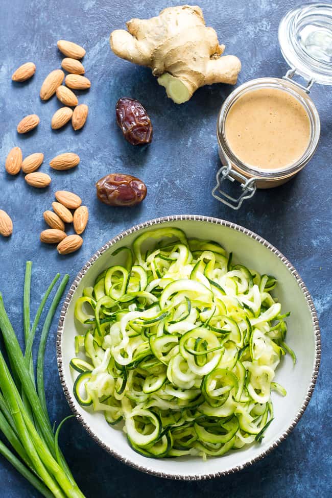 These almond butter sesame zucchini noodles are a delicious healthy makeover of classic sesame peanut noodles!  The creamy almond butter sauce is sweetened just the right amount with dates and loaded with chopped almonds and scallions.  Paleo, Whole30, and Vegan too! 