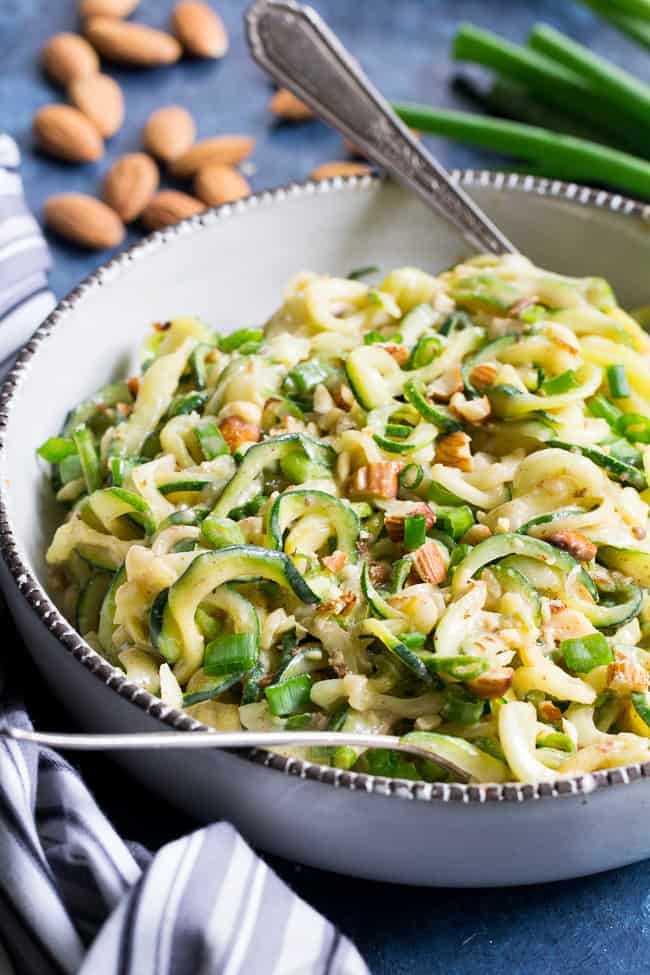 These almond butter sesame zucchini noodles are a delicious healthy makeover of classic sesame peanut noodles!  The creamy almond butter sauce is sweetened just the right amount with dates and loaded with chopped almonds and scallions.  Paleo, Whole30, and Vegan too! 