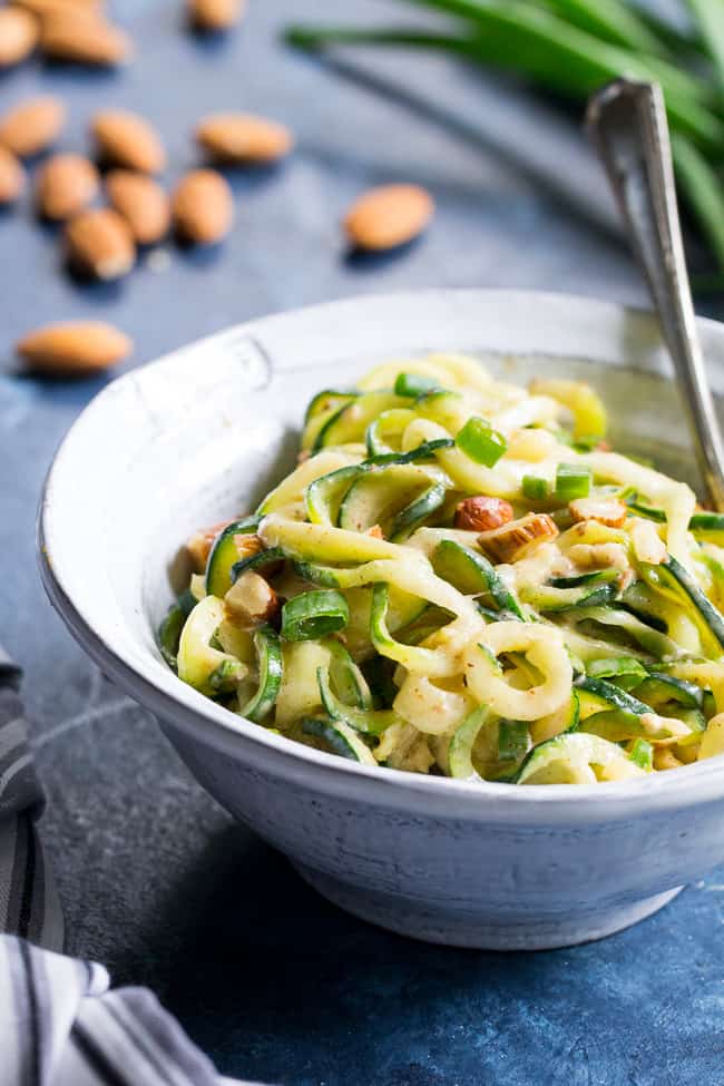 These almond butter sesame zucchini noodles are a delicious healthy makeover of classic sesame peanut noodles!  The creamy almond butter sauce is sweetened just the right amount with dates and loaded with chopped almonds and scallions.  Paleo, Whole30, and Vegan too! 