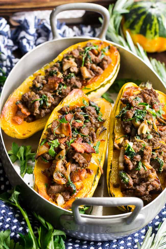 Delicata squash is roasted to perfection and stuffed with ground beef, caramelized onions, bacon, spinach, mushrooms and seasonings.  This cozy paleo and Whole30 stuffed squash is great for any meal or as a side dish.   Savory, filling and healthy!