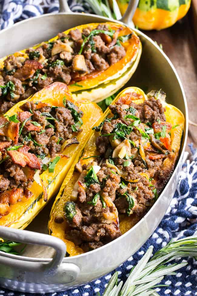 Delicata squash is roasted to perfection and stuffed with ground beef, caramelized onions, bacon, spinach, mushrooms and seasonings.  This cozy paleo and Whole30 stuffed squash is great for any meal or as a side dish.   Savory, filling and healthy!