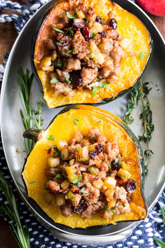 This Roasted Stuffed Acorn Squash is filled with all your favorites - sausage, apples, cranberries, onions, celery and savory herbs. The stuffing is packed with savory/sweet flavors and the perfect addition to a holiday gathering, or for any meal!  Paleo, gluten free, Whole30 compliant.