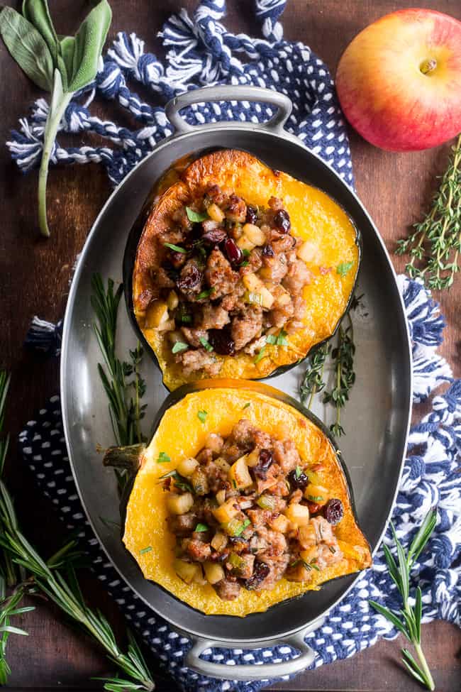 This Roasted Stuffed Acorn Squash is filled with all your favorites - sausage, apples, cranberries, onions, celery and savory herbs. The stuffing is packed with savory/sweet flavors and the perfect addition to a holiday gathering, or for any meal!  Paleo, gluten free, Whole30 compliant.