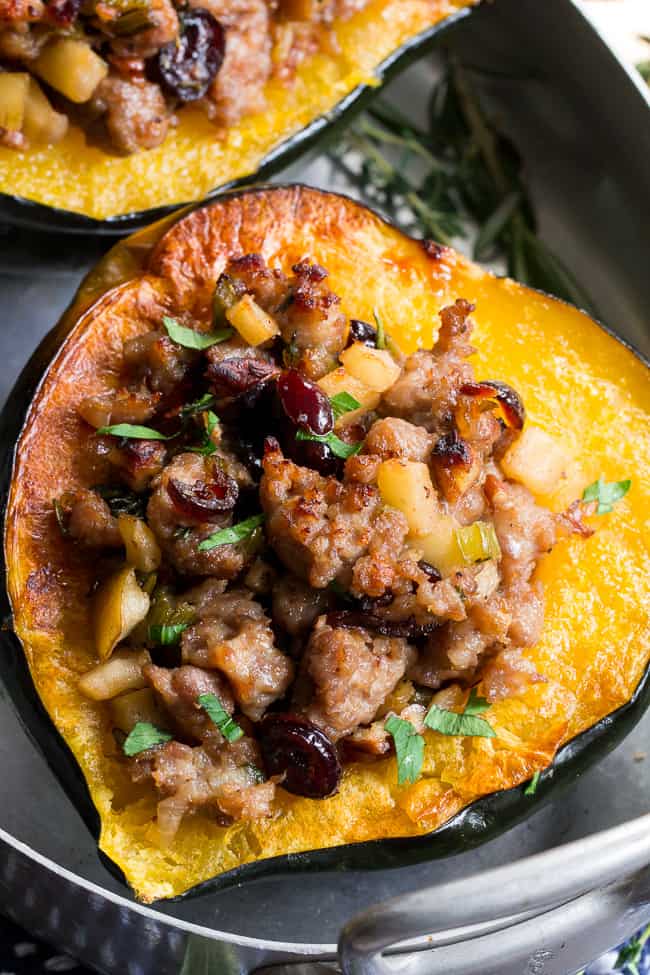 This Roasted Stuffed Acorn Squash is filled with all your favorites - sausage, apples, cranberries, onions, celery and savory herbs. The stuffing is packed with savory/sweet flavors and the perfect addition to a holiday gathering, or for any meal!  Paleo, gluten free, Whole30 compliant.